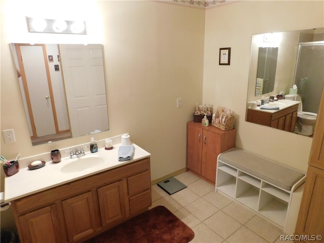 bathroom with tile patterned floors, vanity, and walk in shower