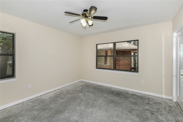 unfurnished room with ceiling fan and concrete floors