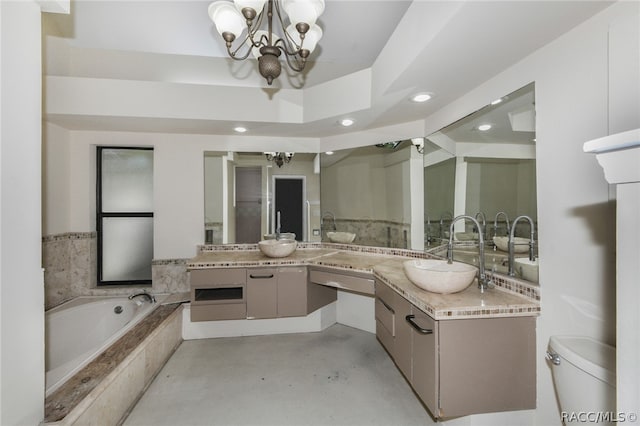 bathroom with vanity, toilet, tiled tub, concrete floors, and a chandelier