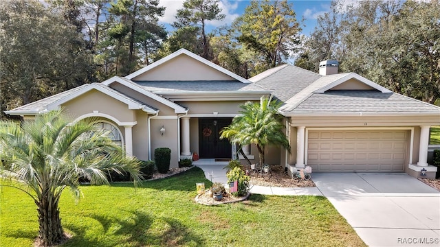 single story home featuring a garage and a front lawn