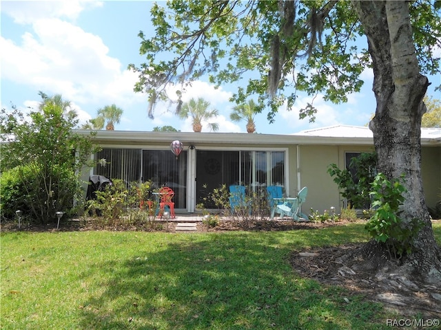 rear view of property featuring a lawn