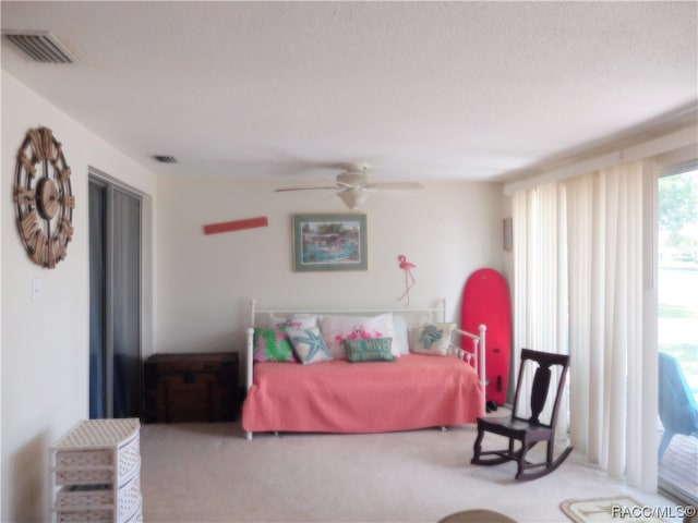 carpeted bedroom featuring access to exterior, a textured ceiling, and ceiling fan