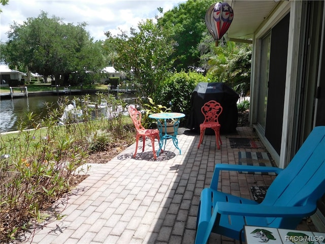 view of patio / terrace with a water view and grilling area