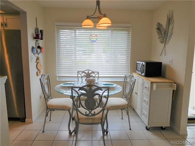 dining area featuring an inviting chandelier and light tile patterned flooring