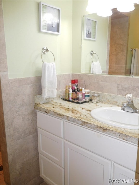 bathroom featuring vanity and tile walls