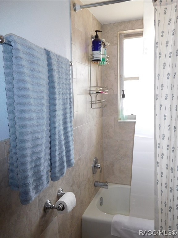 bathroom with shower / bathtub combination with curtain