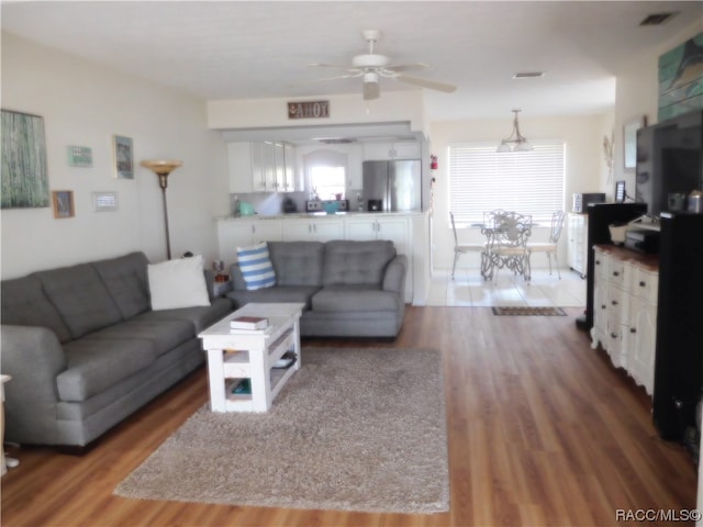 living room featuring ceiling fan and wood-type flooring