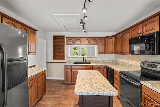 218 N Osceola Ave, Inverness, FL 34450 - kitchen featuring black appliances, wood finished floors, tasteful backsplash, brown cabinets, and light stone counters
