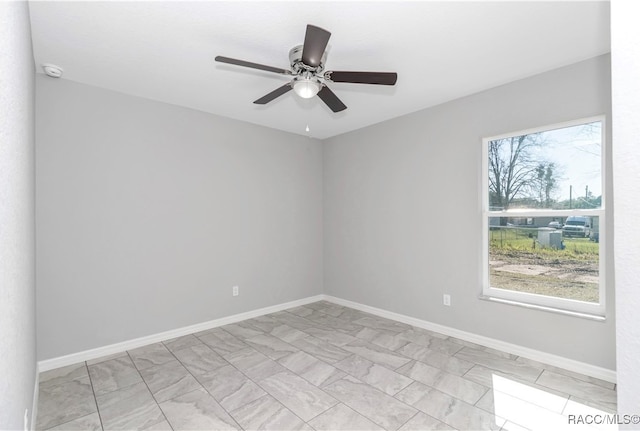 empty room featuring ceiling fan and plenty of natural light