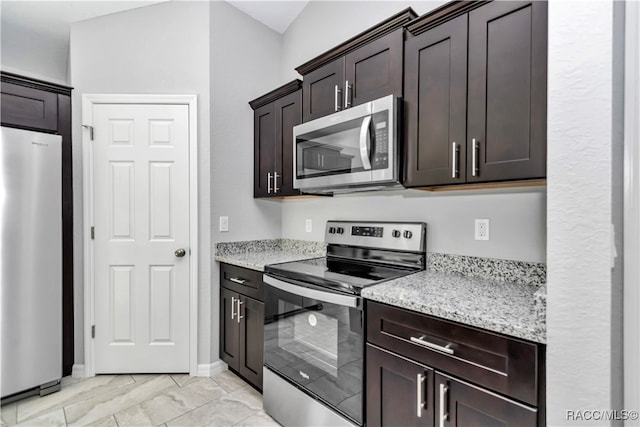 kitchen with dark brown cabinetry, stainless steel appliances, and light stone countertops