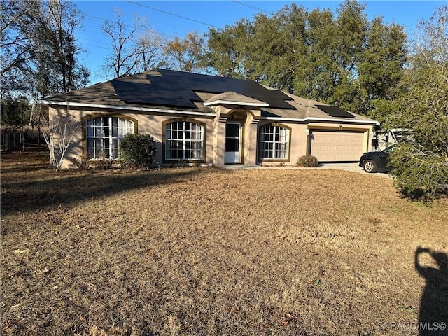 ranch-style home featuring a garage and a front lawn