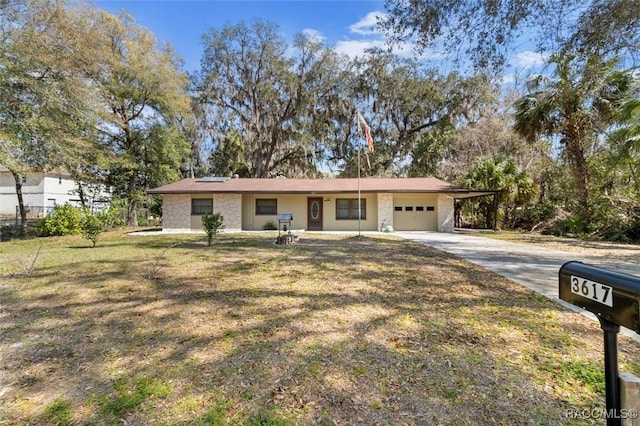 ranch-style house featuring a front lawn, concrete driveway, stone siding, and an attached garage