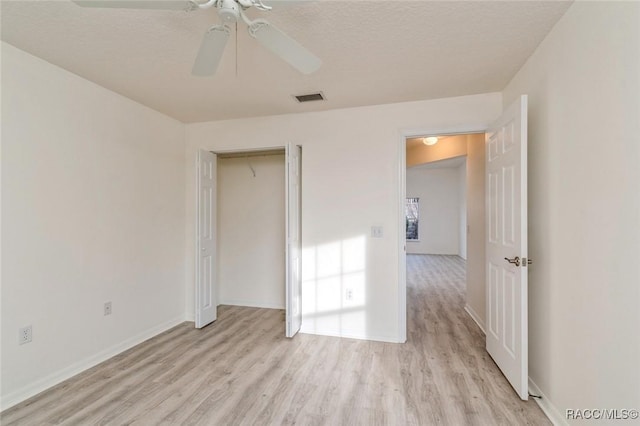 interior space with ceiling fan, a textured ceiling, light wood-type flooring, and a closet