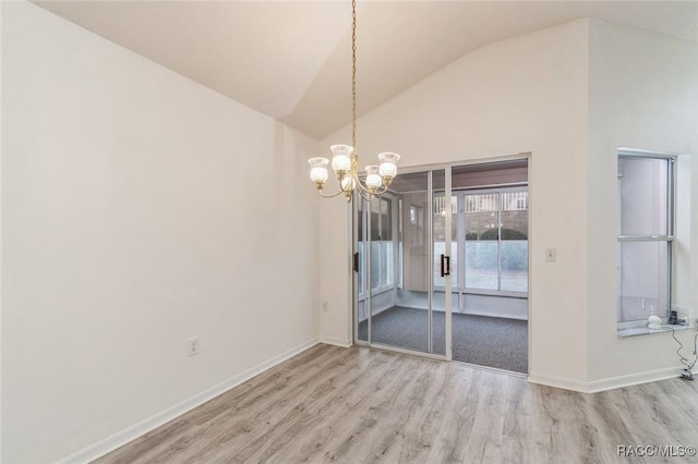 unfurnished dining area featuring hardwood / wood-style flooring, lofted ceiling, and an inviting chandelier