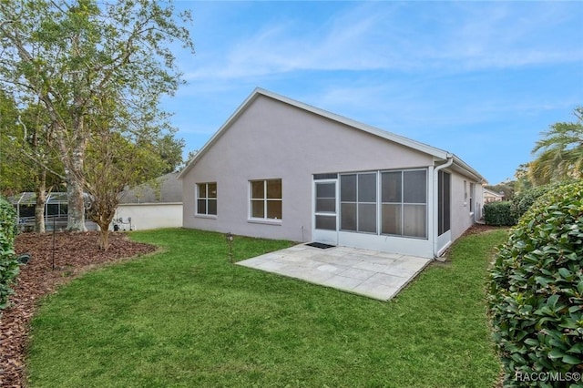 rear view of property with a lawn and a patio