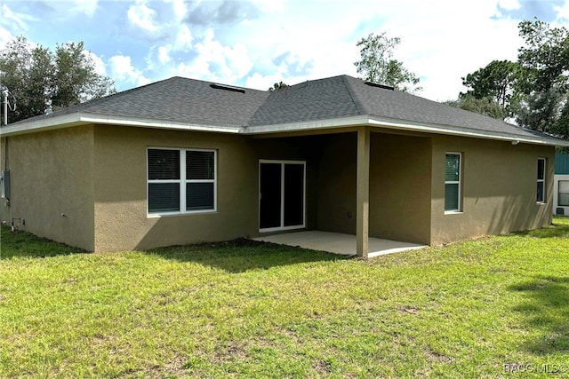 rear view of property featuring a patio area and a yard