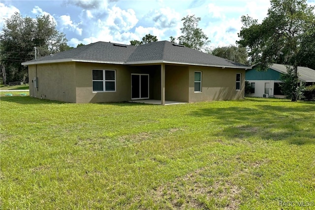 back of property with a patio area and a yard