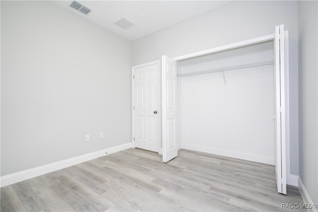 unfurnished bedroom featuring a closet and light wood-type flooring