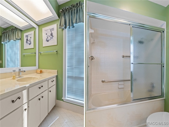 bathroom with tile patterned floors, vanity, and shower / bath combination with glass door