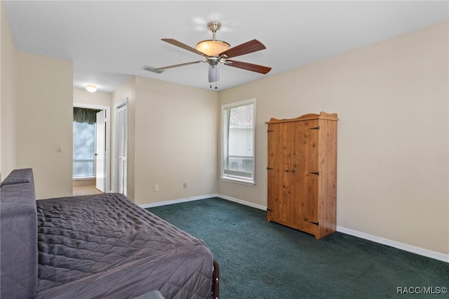 unfurnished bedroom featuring ceiling fan, dark carpet, ensuite bathroom, and a closet