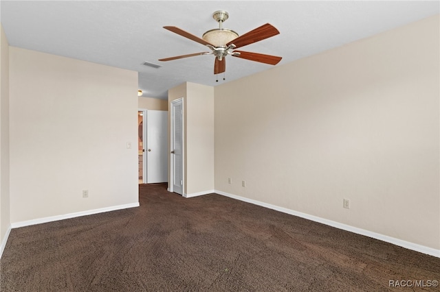 empty room featuring dark colored carpet and ceiling fan