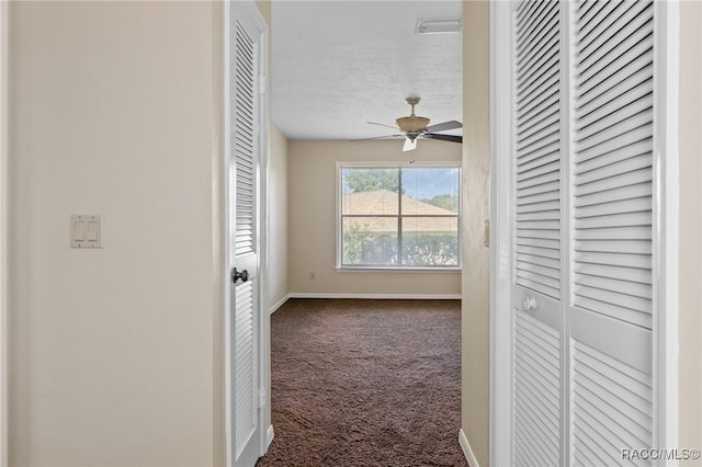 corridor with carpet flooring and a textured ceiling