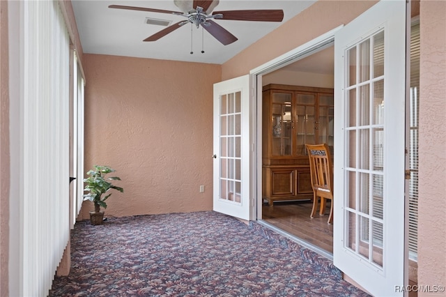 unfurnished sunroom featuring french doors and ceiling fan