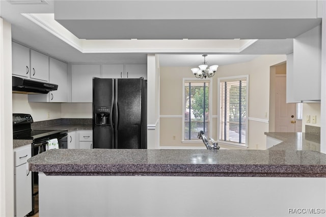 kitchen with kitchen peninsula, a tray ceiling, and black appliances