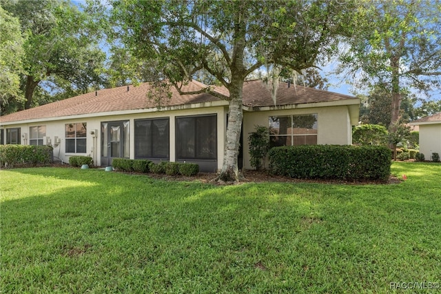 rear view of house featuring a lawn