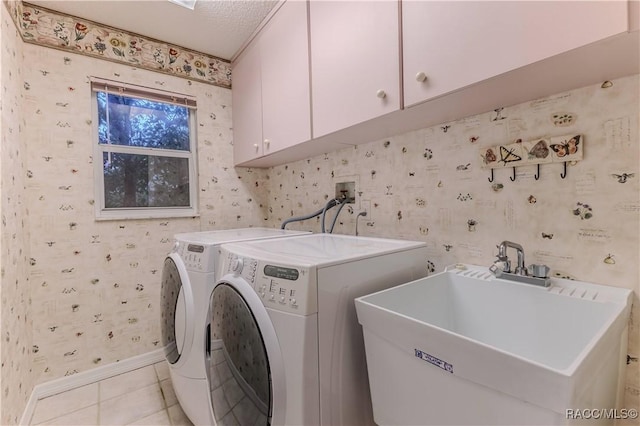 clothes washing area with separate washer and dryer, sink, light tile patterned floors, and cabinets