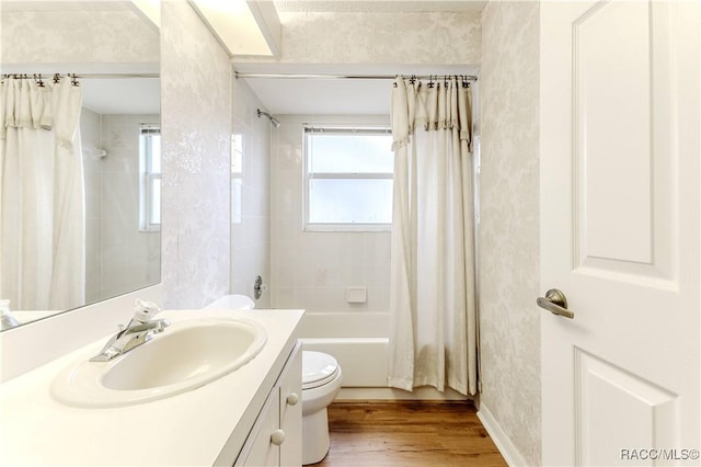 full bathroom with wood-type flooring, toilet, shower / bath combo with shower curtain, and vanity