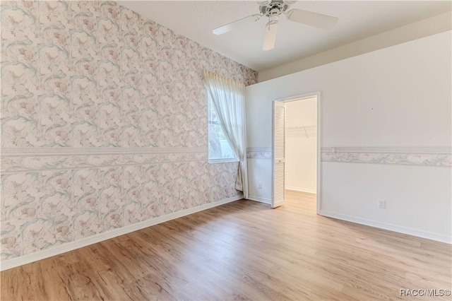 spare room with ceiling fan and light wood-type flooring