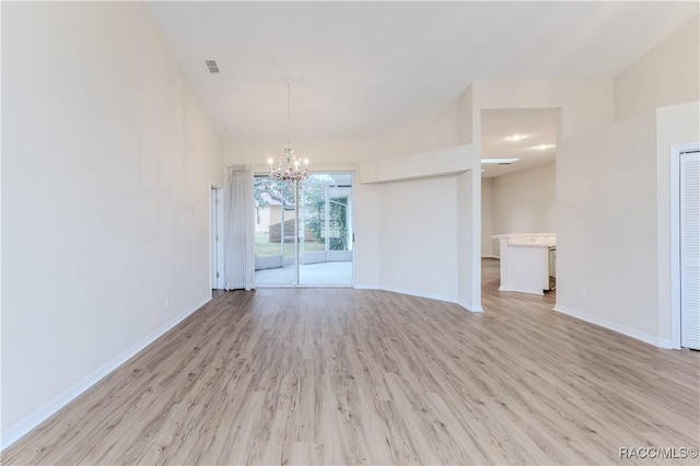 unfurnished room featuring an inviting chandelier and light hardwood / wood-style floors