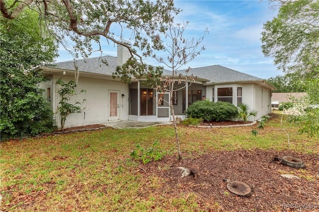 rear view of property featuring a yard