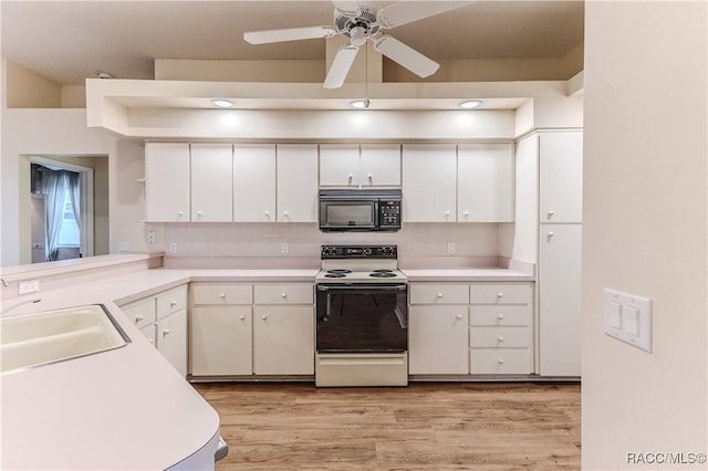 kitchen with sink, tasteful backsplash, light wood-type flooring, white electric stove, and white cabinets