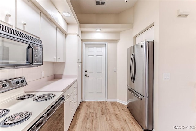 kitchen featuring electric range oven, stainless steel refrigerator, white cabinets, and light wood-type flooring