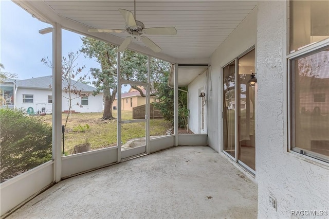 unfurnished sunroom featuring ceiling fan