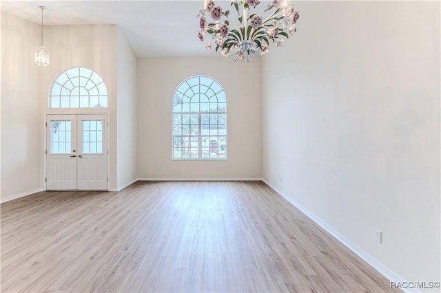 interior space featuring french doors, a chandelier, and light hardwood / wood-style flooring