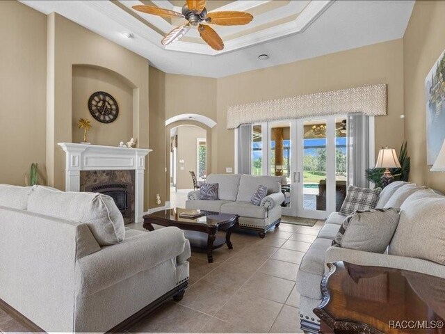 2622 N Carnoustie Loop, Lecanto, FL 34461 - living area featuring french doors, a ceiling fan, a premium fireplace, light tile patterned flooring, and a towering ceiling