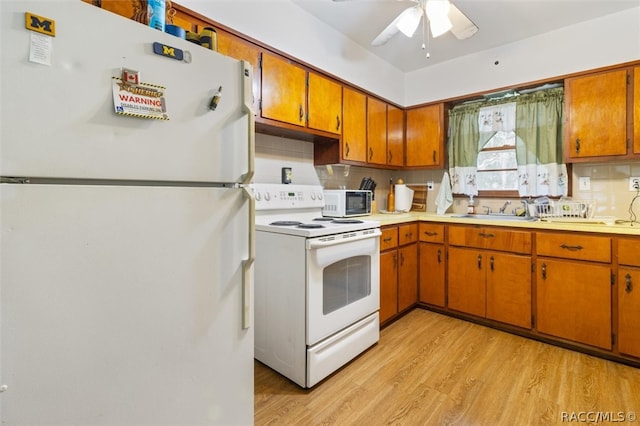 kitchen with light wood-type flooring, tasteful backsplash, white appliances, ceiling fan, and sink