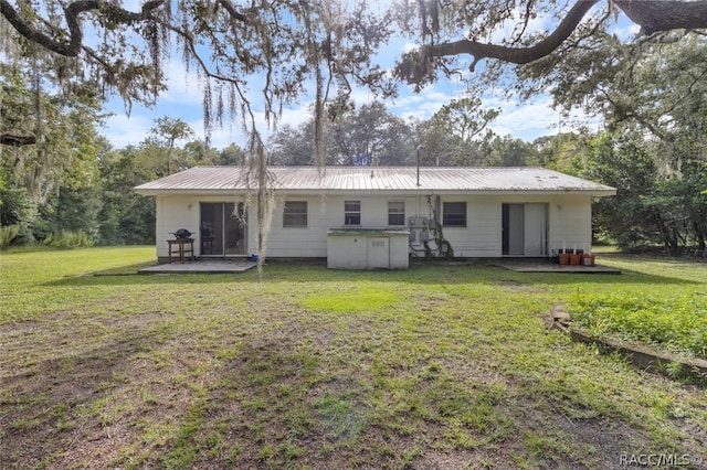 back of house featuring a yard and a patio