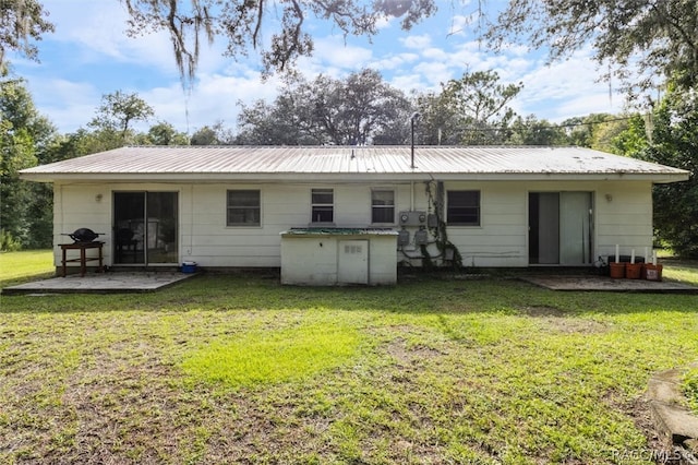 rear view of house with a lawn and a patio area