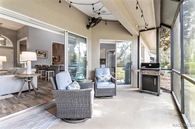 sunroom featuring vaulted ceiling with beams and track lighting