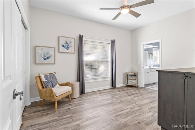 living area with ceiling fan and light hardwood / wood-style floors