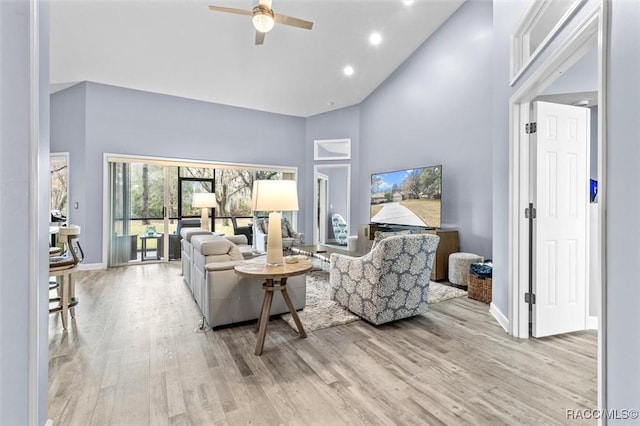 living room featuring ceiling fan, light wood-type flooring, and high vaulted ceiling