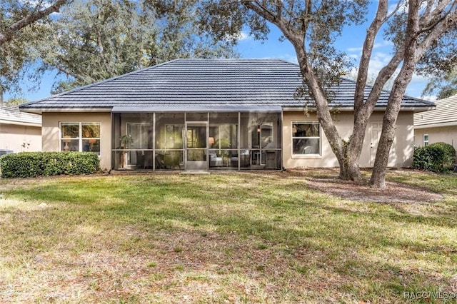 back of property with a lawn and a sunroom