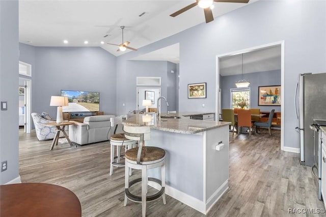 kitchen featuring a breakfast bar area, sink, light hardwood / wood-style floors, and decorative light fixtures