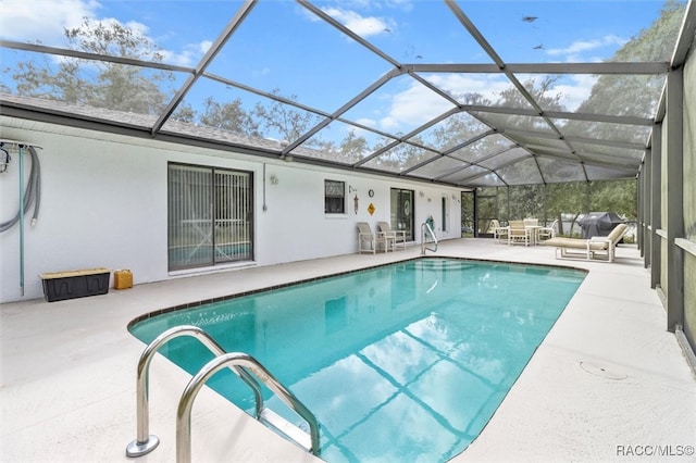 view of pool featuring glass enclosure and a patio