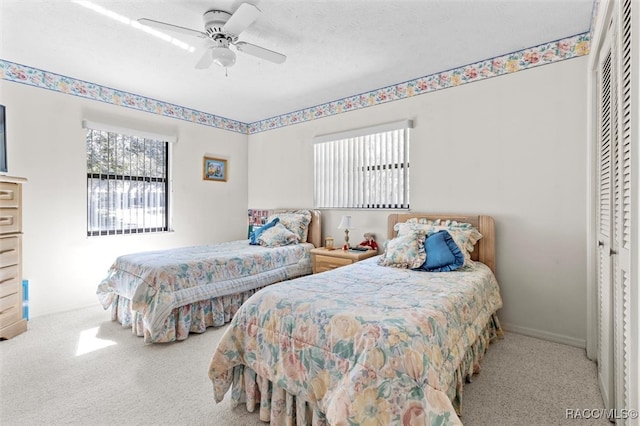 bedroom with ceiling fan, a closet, carpet floors, and a textured ceiling