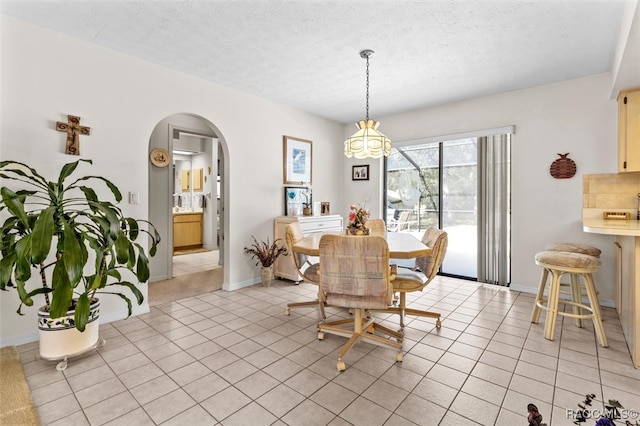 dining area featuring light tile patterned floors and a textured ceiling